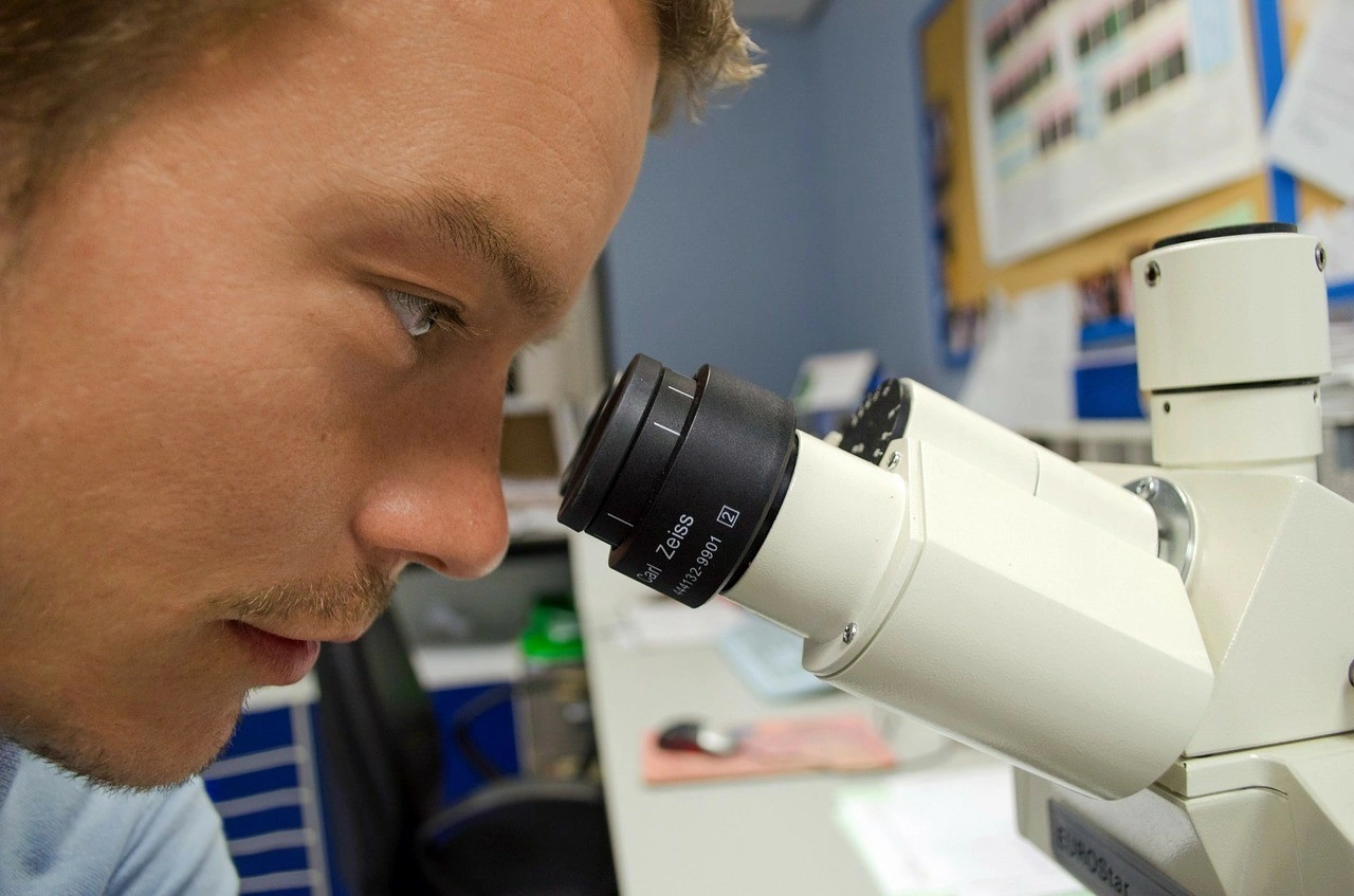 Researcher looking into a microscope